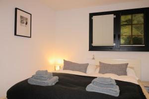 1 dormitorio con 1 cama con toallas en CAYA Bijou im Herzen von Zermatt, en Zermatt