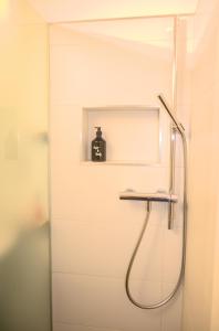 baño con ducha y un contenedor negro en un estante en CAYA Bijou im Herzen von Zermatt, en Zermatt