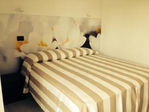a bedroom with a bed with white flowers on the wall at Gl106 in Santa Severa