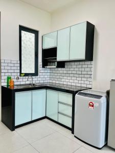 a kitchen with blue cabinets and a white refrigerator at Meritus Residensi, Prai Penang in Perai