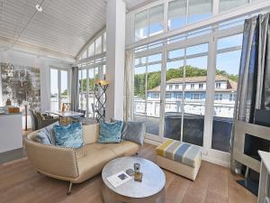 a living room with a couch and a large window at Villa "Johanna" Sellin - Penthouse "Nautilus" mit Sauna und umlaufendem Balkon in Ostseebad Sellin