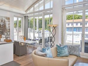 a living room with a couch and a table at Villa "Johanna" Sellin - Penthouse "Nautilus" mit Sauna und umlaufendem Balkon in Ostseebad Sellin