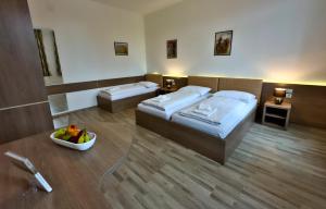 Cette chambre comprend 2 lits et une corbeille de fruits. dans l'établissement Aparthotel Neudörfl, à Neudörfl