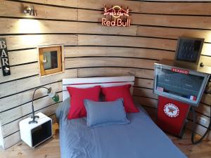 Schlafzimmer mit einem Bett mit roten Kissen und einem TV in der Unterkunft Tour de charme atypique in Beauregard-lʼÉvêque