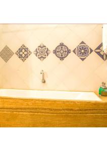 a bath tub in a bathroom with tiles on the wall at villa goa in Cola