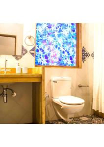 a bathroom with a toilet and a sink and a mirror at villa goa in Cola