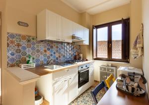 una cucina con armadi bianchi e piano cottura di Casa Il Gelsomino - Irpinia a Santo Stefano del Sole