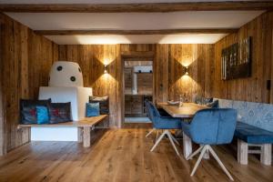una sala da pranzo con pareti in legno, tavolo e sedie blu di Chalet Paula a Ehrwald