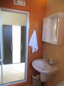 y baño con lavabo y ducha con espejo. en Apartments in Azalia 2 Complex en Nesebar