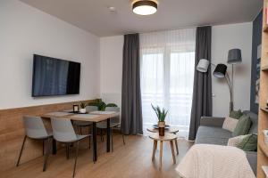 a living room with a table and a couch at Sporthotel Ferlach in Ferlach
