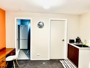 uma cozinha com um frigorífico e um lavatório em Private studio Auckland Self Checkin and 2 Parking Netflix Prime em Auckland
