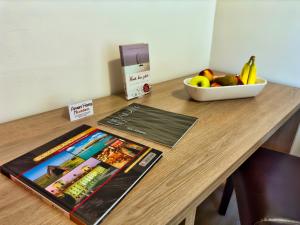 una mesa de madera con revistas y un bol de fruta en Aparthotel Neudörfl en Neudörfl