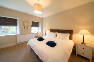 a bedroom with a large bed with two blue towels on it at Riverside Cottage, Bridge of Balgie, Glenlyon, Perthshire 