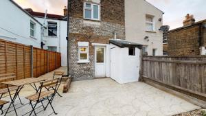 a patio with a wooden fence and a white door at Private Room in a Shared Accommodation in Norwood