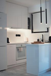 a kitchen with white cabinets and a stove top oven at Becool Apartment in Porto Rafti