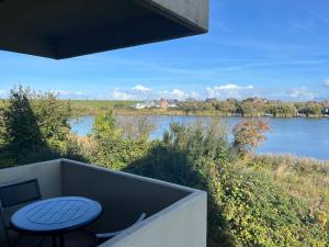 a balcony with a table and a view of a river at Capt'n Cook 2 in Nordstrand