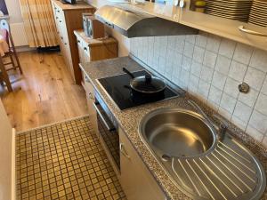 a kitchen with a stove and a pot on a counter at Capt'n Cook 2 in Nordstrand