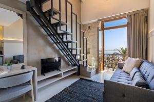 a living room with a couch and a tv at Mitos-Suites in Rethymno
