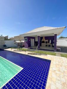 eine Villa mit einem Pool und einem Haus in der Unterkunft casa de praia com piscina e hidromassagem in Arraial do Cabo