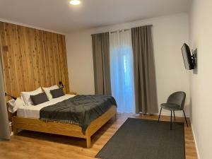 1 dormitorio con 1 cama y 1 silla en Vila Rosario, en Ponta Delgada