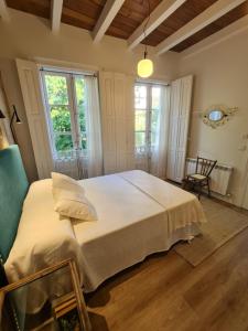 1 dormitorio con 1 cama blanca grande y ventanas en Pensión A Xanela, en Pontevedra