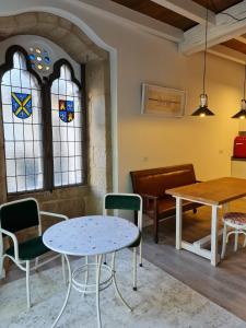 a table and chairs in a room with stained glass windows at Pensión A Xanela in Pontevedra