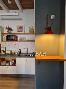 a kitchen with white cabinets and a bar sign on the counter at Pensión A Xanela in Pontevedra