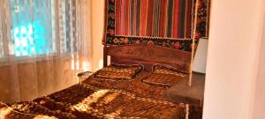 ein Schlafzimmer mit einem Holzbett mit einem Teppich darüber in der Unterkunft Papi Aygi in Alawerdi