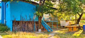 a blue building with a blue staircase next to a tree at Papi Aygi in Alaverdi