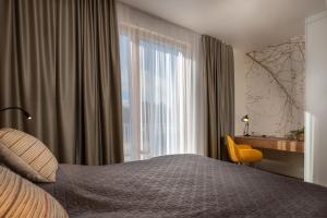 - une chambre avec un lit, un bureau et une fenêtre dans l'établissement TATRYSTAY Hillside Apartments, à Dolný Kubín