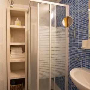 een badkamer met een douche en een glazen deur bij Modern apartment directly on the beach with WiFi and air conditioning in El Campello