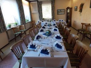 a long dining room with white tables and chairs at Landgasthof Allerparadies in Langlingen