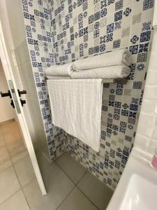 ein Badezimmer mit blau und weiß gefliesten Wänden und Handtüchern in der Unterkunft Deluxe Apartment #CasaMihai Free Parking in Braşov