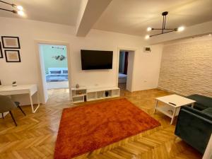 a living room with a flat screen tv and a rug at Deluxe Apartment #CasaMihai Free Parking in Braşov