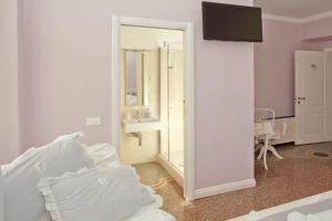 Habitación blanca con lavabo y espejo en B&B Elisir, en Albenga