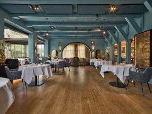 a dining room with white tables and chairs at De Nederlanden, Restaurant & Boutique Hotel in Vreeland