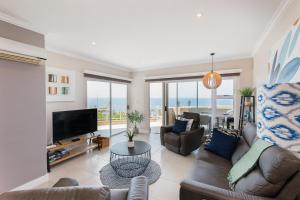 a living room with a couch and a tv at Les Dauphine 13 in Ballito