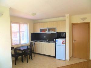 uma cozinha com um frigorífico azul e uma mesa e cadeiras em Apartments in Azalia 2 Complex em Nessebar