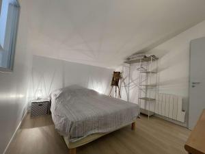 1 dormitorio con 1 cama en una habitación blanca en Maison Dompierre-sur-Mer, 2 pièces, 4 personnes - FR-1-246-603, en Dompierre-sur-Mer