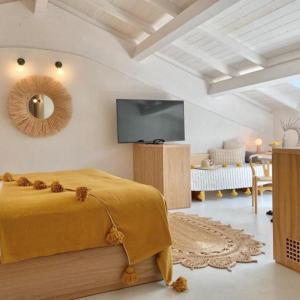 a bedroom with a yellow bed and a flat screen tv at Santa Lucia Maccarese - Residenza Agricola in Maccarese