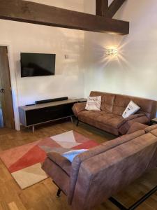 a living room with a couch and a flat screen tv at The Radnor Arms in Malmesbury