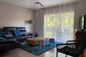ein Wohnzimmer mit einem Sofa und einem Tisch in der Unterkunft Maison de vacances à Gramat in Gramat