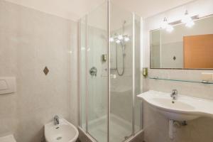a bathroom with a shower and a toilet and a sink at Guesthouse St Nikolaus in Ultimo