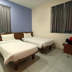a room with two beds and a window at Sharman Suites in Pune