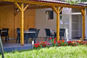 un patio con mesas, sillas y flores en Pension Happy Day en Sibiu