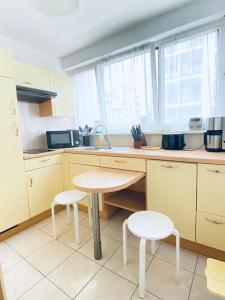 kuchnia ze stołem i 2 stołkami w obiekcie CityCosy ORANGERIE Strasbourg Appartement 2 pièces en face de parc de L'Orangerie avec un parking souterrain compris w Strasburgu