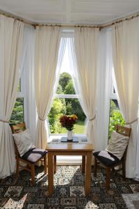 uma sala de estar com uma mesa e duas cadeiras e uma janela em Abbey View Holiday Flats em Torquay