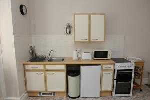 a kitchen with a sink and a counter with a microwave at Abbey View Holiday Flats in Torquay