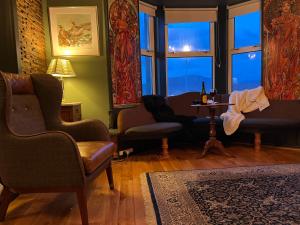 sala de estar con sillas, mesa y ventana en Kilda House en Leverburgh