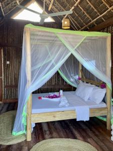 a bed in a room with a mosquito net at Mwananchi Bungalows in Paje